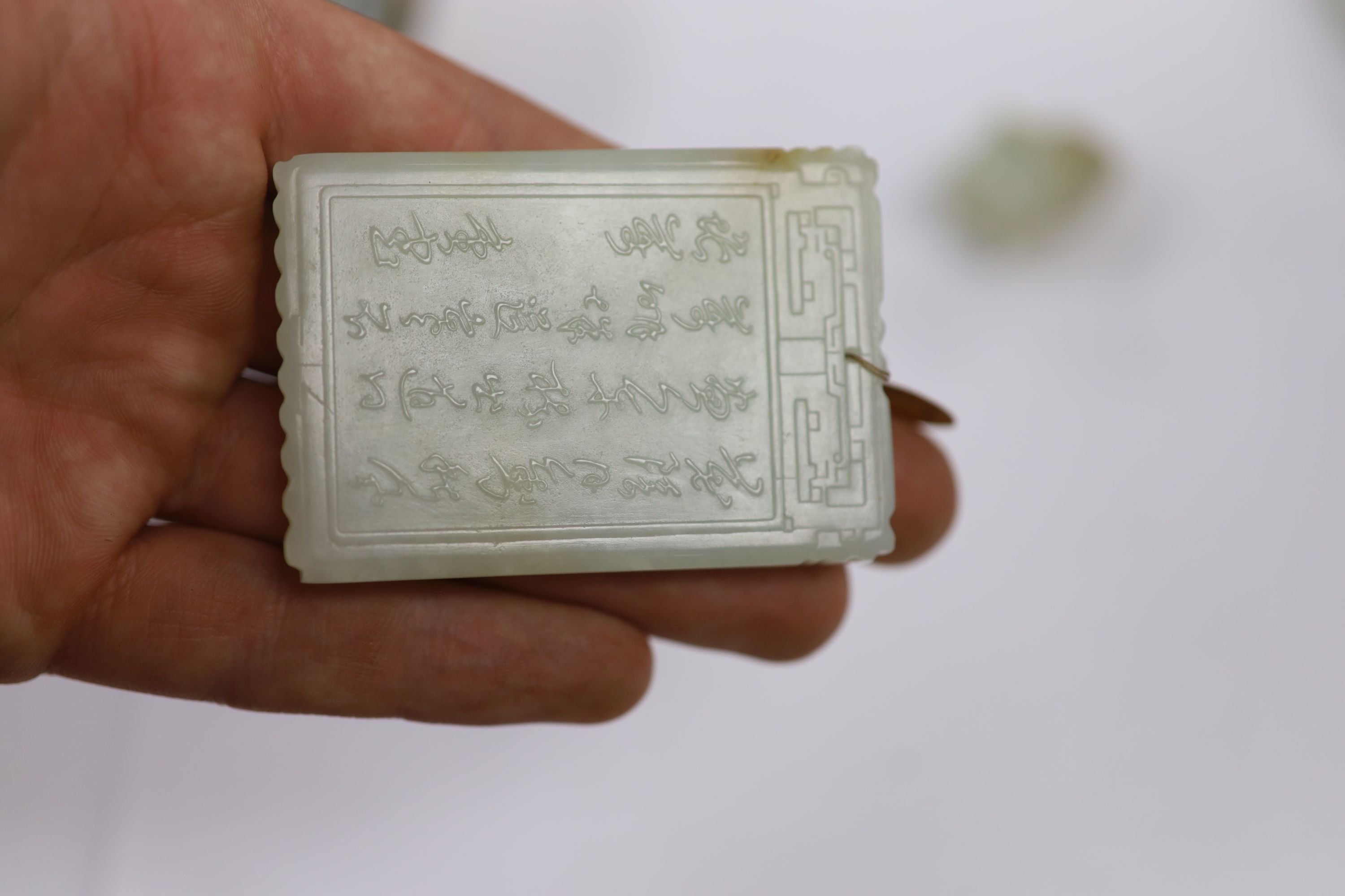 A Chinese pale celadon jade belt hook and a plaque